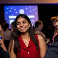 A grad smiles and laughs with friends